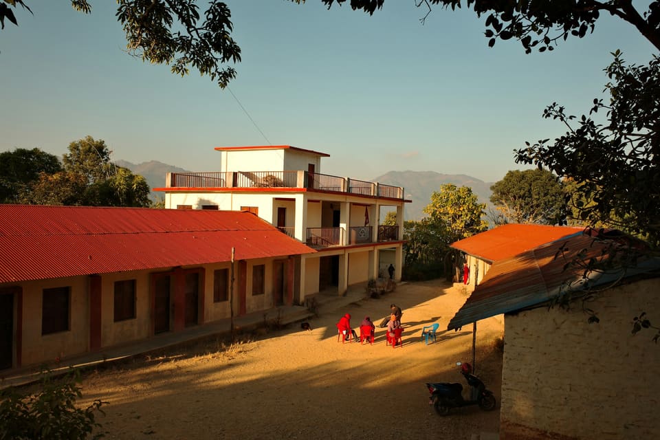 School buildings in the hills with children playing in the courtyard