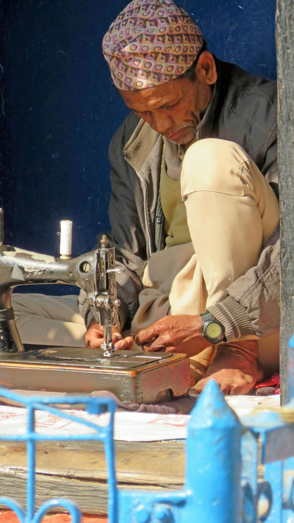 Hands guiding cloth through a treadle sewing machine